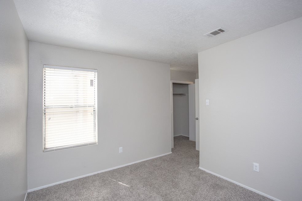 A room with a window and carpeted floor.